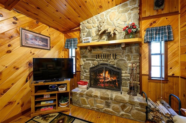 living room featuring wood ceiling, wooden walls, wood-type flooring, a fireplace, and lofted ceiling