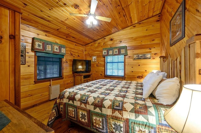 bedroom featuring ceiling fan, wood walls, vaulted ceiling, wood ceiling, and hardwood / wood-style flooring