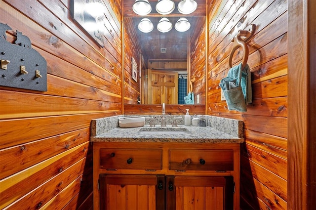 bathroom with vanity and wooden walls