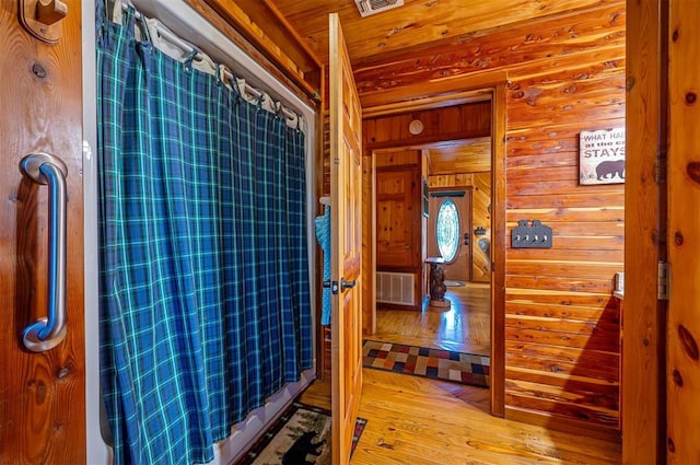 bathroom featuring wood walls and hardwood / wood-style floors