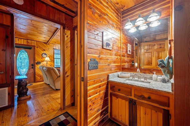 bathroom with wooden walls, vanity, wood ceiling, and hardwood / wood-style flooring