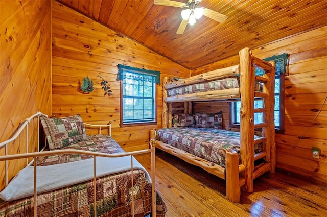 bedroom featuring wood ceiling, vaulted ceiling, ceiling fan, wooden walls, and hardwood / wood-style floors