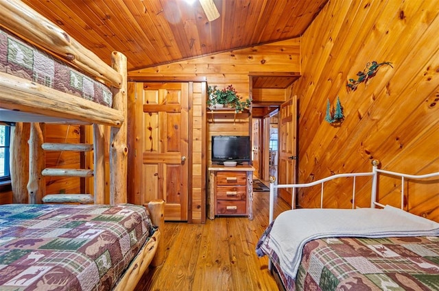 bedroom featuring light hardwood / wood-style flooring, wood ceiling, lofted ceiling, and wood walls