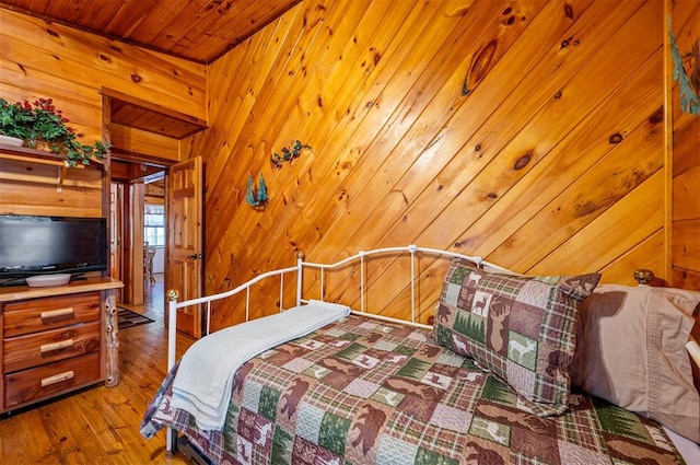 bedroom featuring hardwood / wood-style floors, wooden walls, and wood ceiling