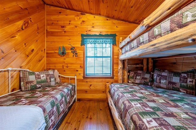 bedroom with wood ceiling, wood walls, wood-type flooring, and lofted ceiling