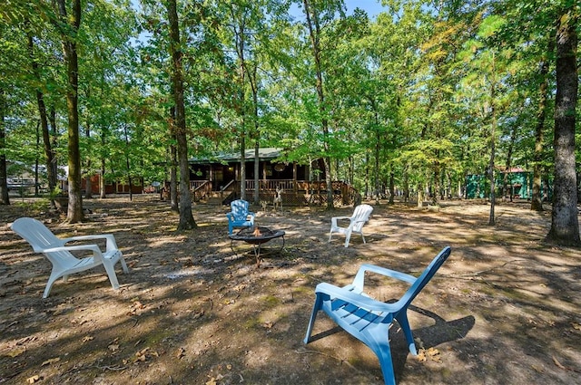 view of playground featuring a deck and an outdoor fire pit