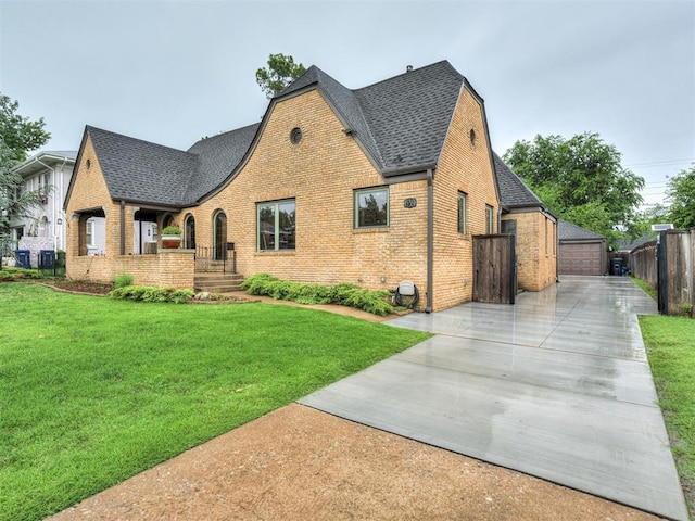 view of front facade with an outbuilding, a front lawn, and a garage