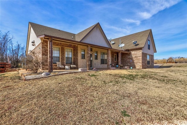 rear view of property featuring a patio area and a yard