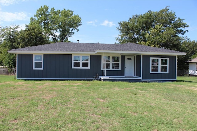 ranch-style home featuring covered porch and a front lawn