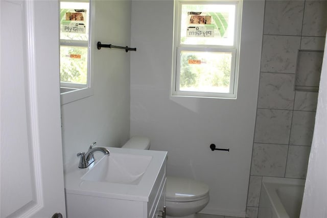 bathroom featuring a bathing tub, vanity, and toilet