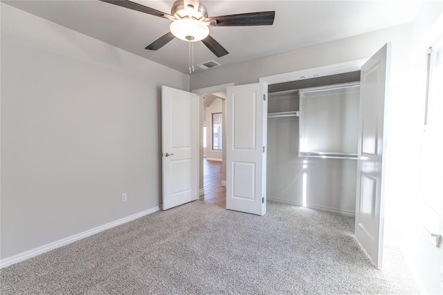 unfurnished bedroom featuring ceiling fan, a closet, and light carpet