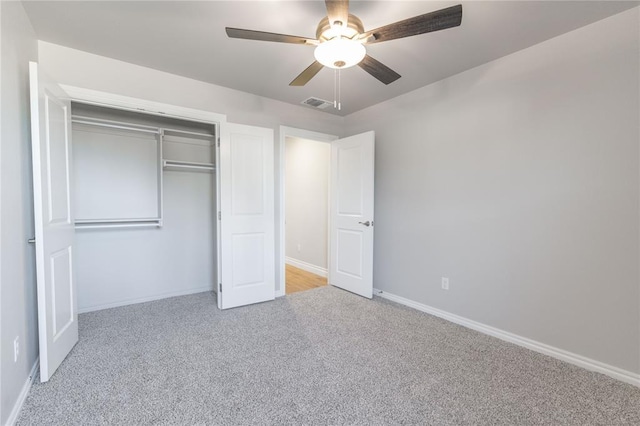 unfurnished bedroom featuring light colored carpet, ceiling fan, and a closet