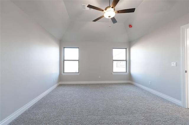 carpeted spare room featuring lofted ceiling, ceiling fan, and a healthy amount of sunlight