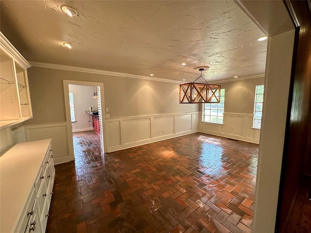 interior space with a textured ceiling and crown molding