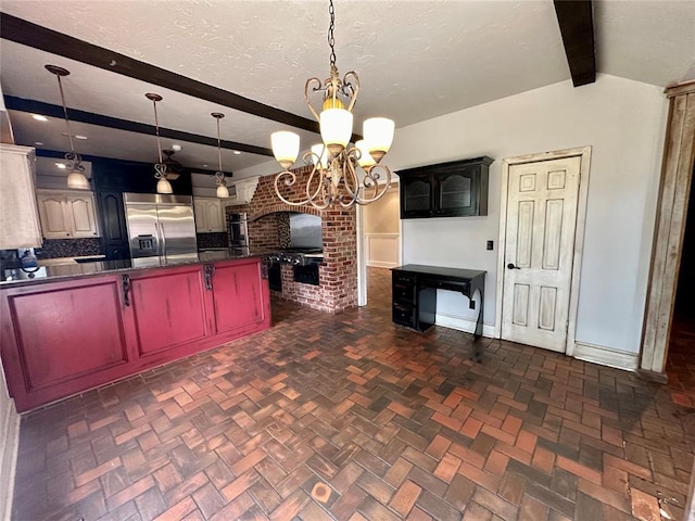 kitchen with hanging light fixtures, tasteful backsplash, beamed ceiling, stainless steel built in refrigerator, and a chandelier