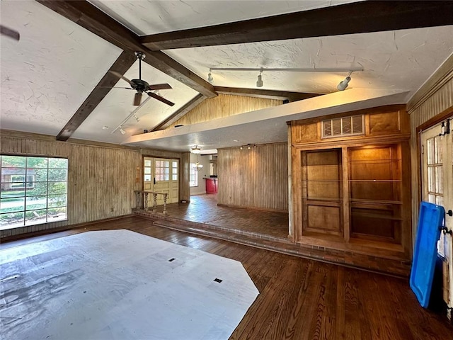 unfurnished room featuring vaulted ceiling with beams, dark hardwood / wood-style floors, ceiling fan, and wood walls