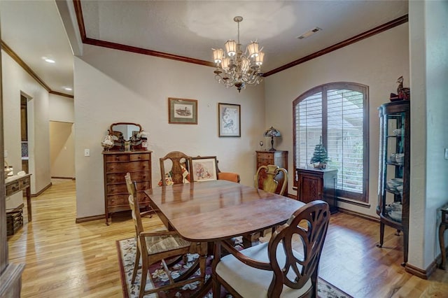 dining room with a chandelier, crown molding, and light hardwood / wood-style floors