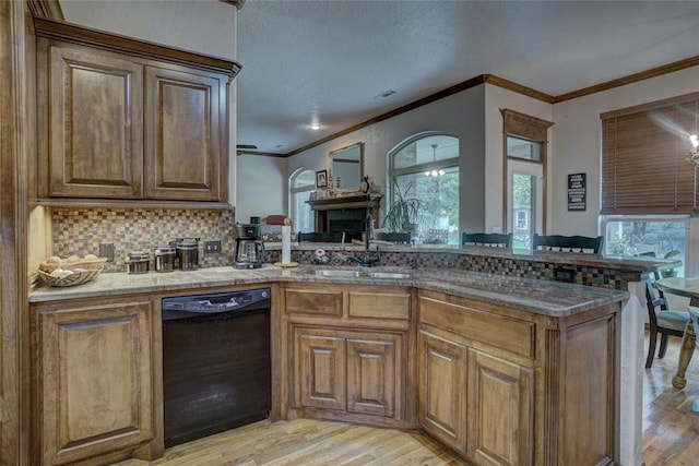 kitchen with dishwasher, sink, light hardwood / wood-style flooring, backsplash, and crown molding