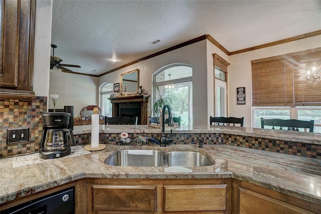 kitchen featuring decorative backsplash, black dishwasher, a healthy amount of sunlight, and sink