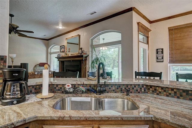 kitchen with ceiling fan, a textured ceiling, a wealth of natural light, and sink