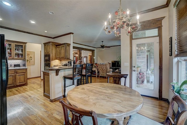 dining room featuring ceiling fan with notable chandelier, light wood-type flooring, and ornamental molding