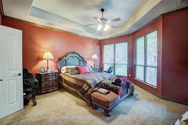 bedroom with a raised ceiling, ceiling fan, carpet floors, and a textured ceiling