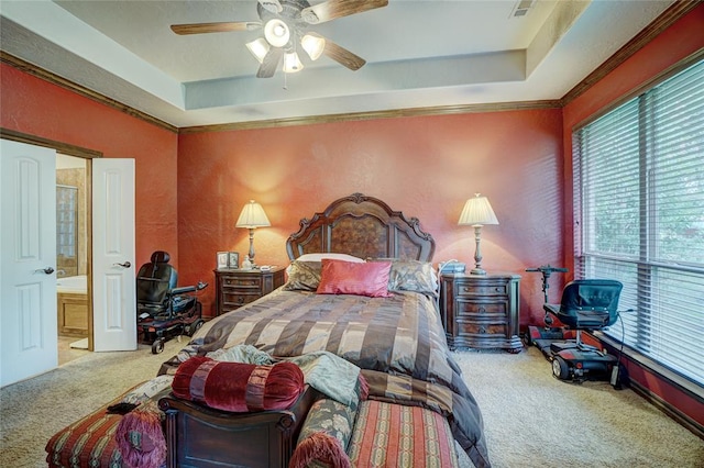 bedroom with carpet, ceiling fan, a raised ceiling, and ensuite bathroom