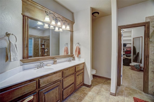 bathroom featuring vanity, a shower with shower door, and toilet