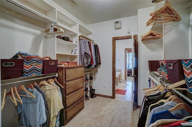 walk in closet with light colored carpet