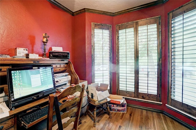 office space with a textured ceiling, wood-type flooring, and crown molding