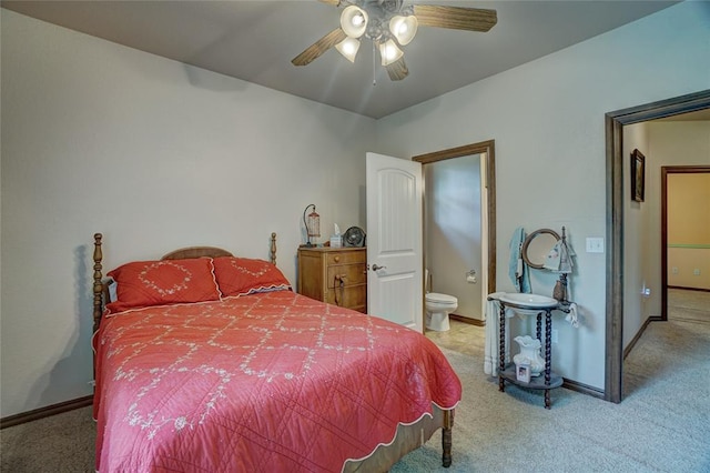 bedroom with ceiling fan, ensuite bathroom, and light carpet