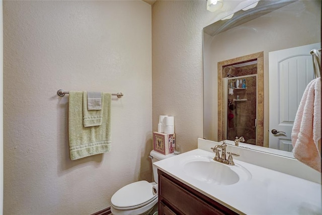 bathroom featuring a tile shower, vanity, and toilet