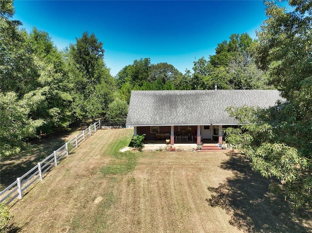 rear view of property featuring a lawn and a porch