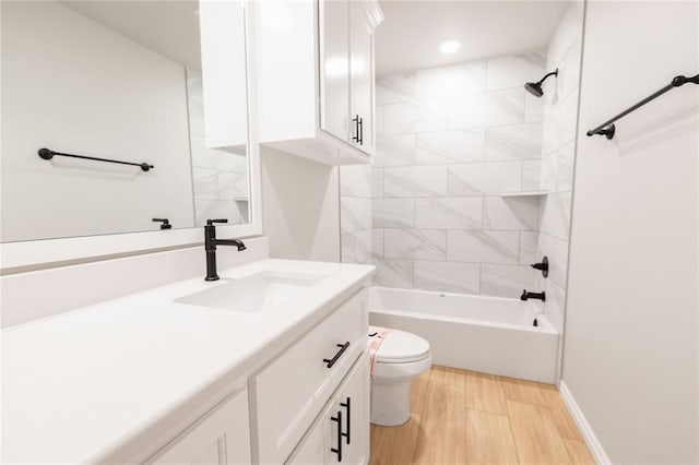 bathroom with vanity, toilet, shower / bath combination, wood finished floors, and baseboards