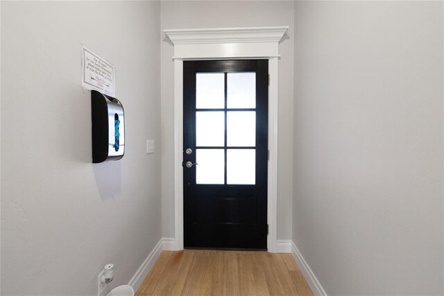doorway to outside with light wood-style floors and baseboards