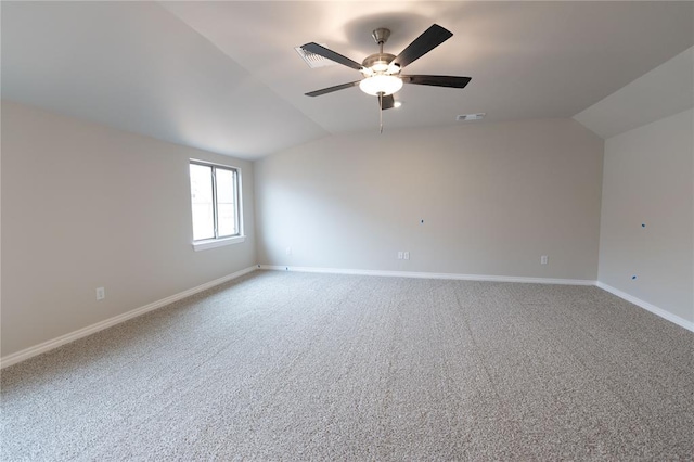 empty room featuring vaulted ceiling, ceiling fan, and carpet flooring