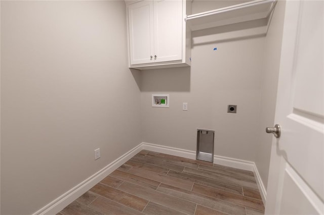 clothes washing area with washer hookup, cabinets, and electric dryer hookup