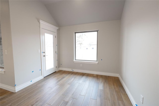 entryway with vaulted ceiling and light hardwood / wood-style flooring