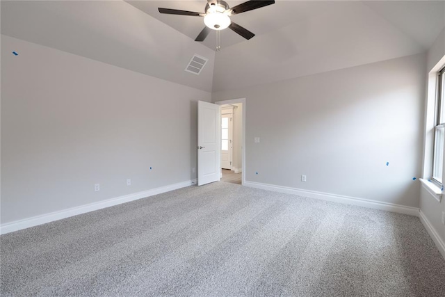 carpeted spare room with ceiling fan, vaulted ceiling, and a wealth of natural light