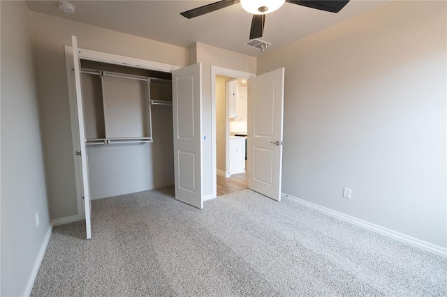 unfurnished bedroom with ceiling fan, a closet, and light colored carpet