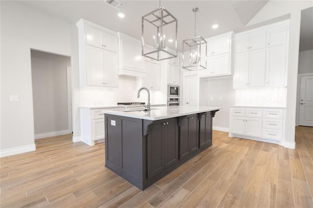 8709 Tyrion Dr, Edmond, OK 73007 - kitchen featuring built in microwave, white cabinetry, light countertops, and a sink