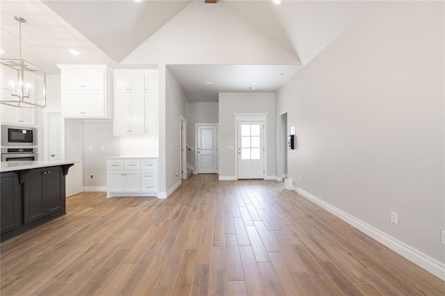 8709 Tyrion Dr, Edmond, OK 73007 - kitchen featuring white cabinets, stainless steel appliances, light wood-type flooring, and light countertops