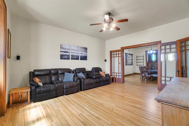 living room featuring french doors, light wood-type flooring, and ceiling fan