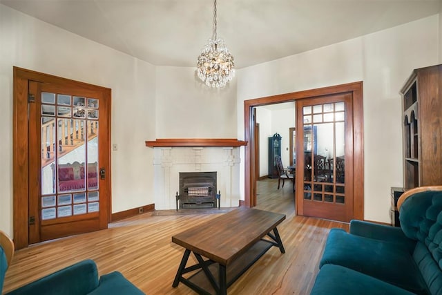 living room with light hardwood / wood-style floors, a wealth of natural light, and an inviting chandelier