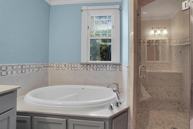 bathroom featuring vanity, ornamental molding, shower with separate bathtub, and tile walls