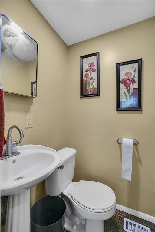 bathroom featuring hardwood / wood-style flooring and toilet