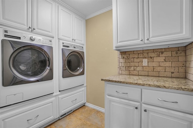 laundry area with cabinets, light tile patterned flooring, crown molding, and washing machine and clothes dryer