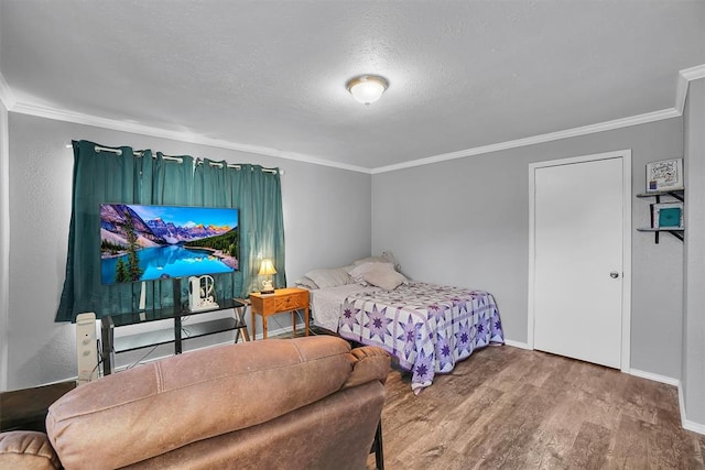 bedroom with hardwood / wood-style flooring, ornamental molding, and a textured ceiling