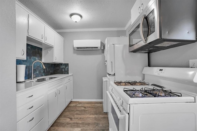 kitchen featuring an AC wall unit, white gas stove, white cabinets, and sink