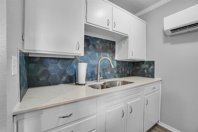 kitchen featuring backsplash, crown molding, sink, a wall mounted AC, and white cabinetry